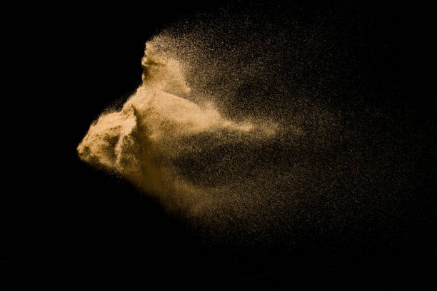 istock Abstract sand cloud. Golden colored sand splash agianst dark background. Yellow sand fly wave in the air. Sand explode on black background ,throwing freeze stop motion. 931083260