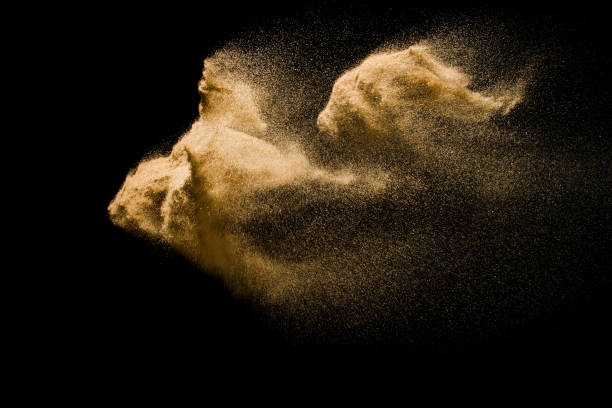 istock Abstract sand cloud. Golden colored sand splash agianst dark background. Yellow sand fly wave in the air. Sand explode on black background ,throwing freeze stop motion. 931083472