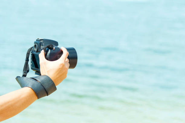 istock Professional camera in man hands on the beach. 931087282