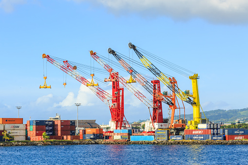Papeete, French Polynesia – March 10, 2018 :  The big cranes and Containers at Large commercial port  in Tahiti PAPEETE, FRENCH POLYNESIA on June 14, 2016