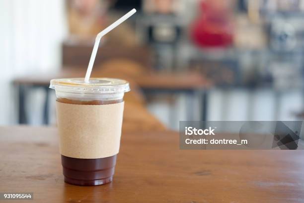 Iced Black Coffee With Brown Paper Sleeve On Wood Table Stock Photo - Download Image Now