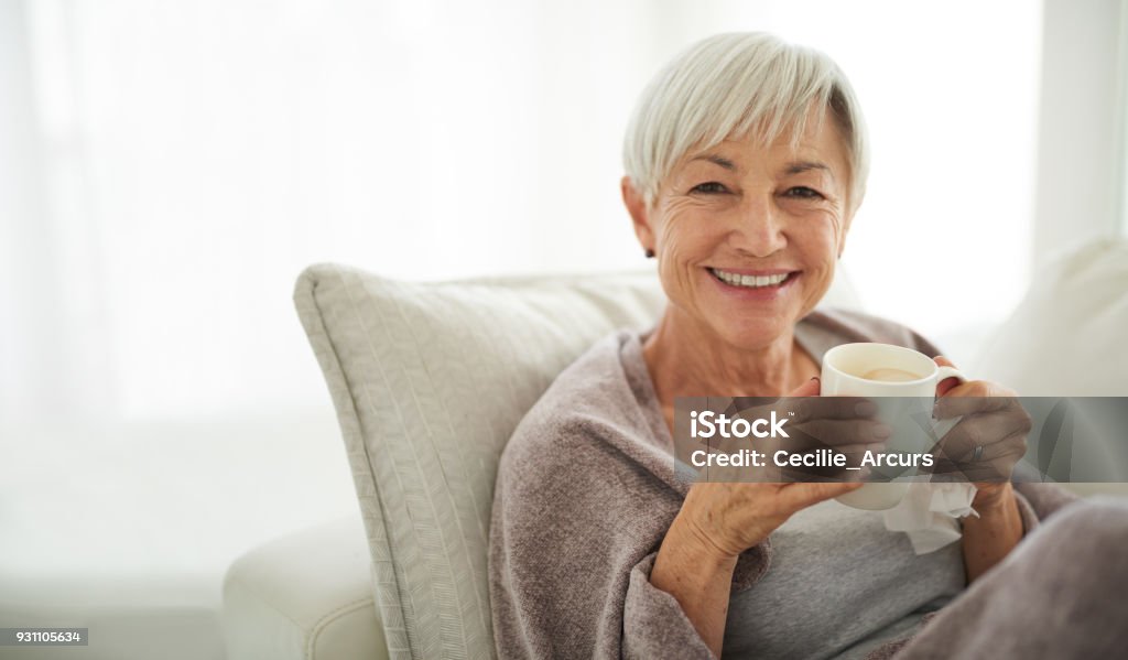 This is exactly how I planned to spend my retirement Shot of a senior woman enjoying a relaxing coffee break on the sofa at home Senior Adult Stock Photo
