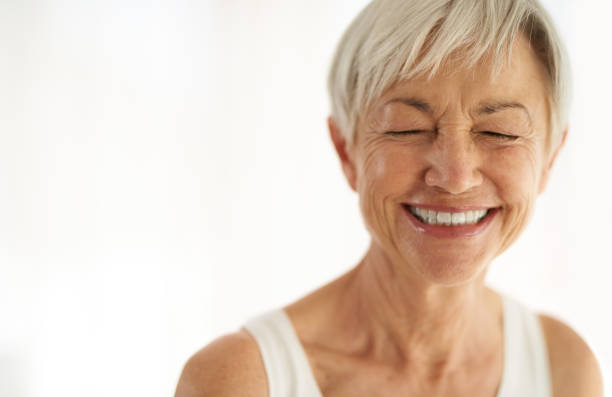 Nothing defies age like positivity Shot of an attractive senior woman laughing at home older woman eyes closed stock pictures, royalty-free photos & images