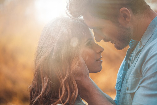 Copy space shot of young man and woman looking at each other just before they kiss.