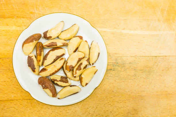 istock Plate with brazil nuts after shell removal. View from above. 931121640