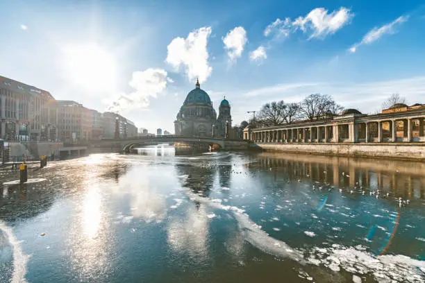 ice floating on river in berlin with cathedral in background