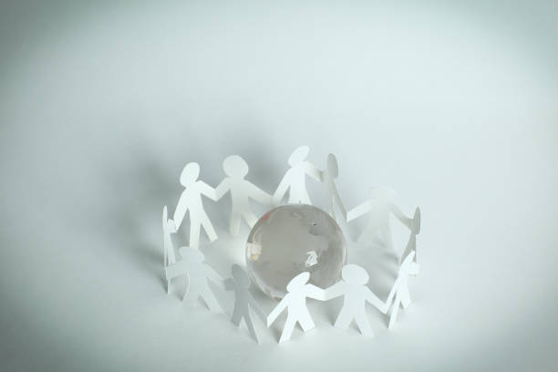 istock team paper men standing around the glass globe 931126758