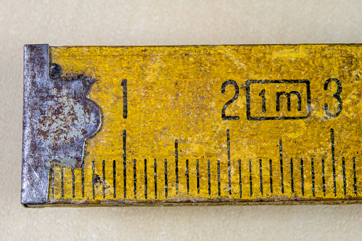Old measure carpentry on a wooden workshop table. Joinery accessories shown in a large magnification. Light background.