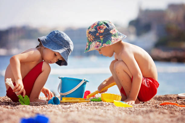 istock Two cute kids, playing in the sand on the beach 931130082