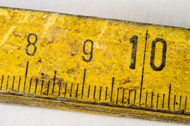This plastic student slide rule from the 1960s is a remarkably adaptable mathematical instrument whose ability to perform calculations such as multiplication and division depends upon the use of logarithmic scales, where larger numbers are closer together than smaller ones. The centre section of the ruler slides to the left and right. This is a close up photograph showing the right-hand end, where the different scales are identified. For example, lined up at this normal setting, the slide rule shows that when x = 10, log x = 1.0.