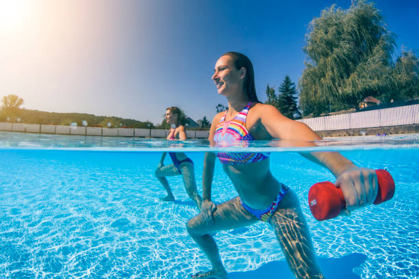 istock Women exercising with dumbbells in swimming pool 931131116