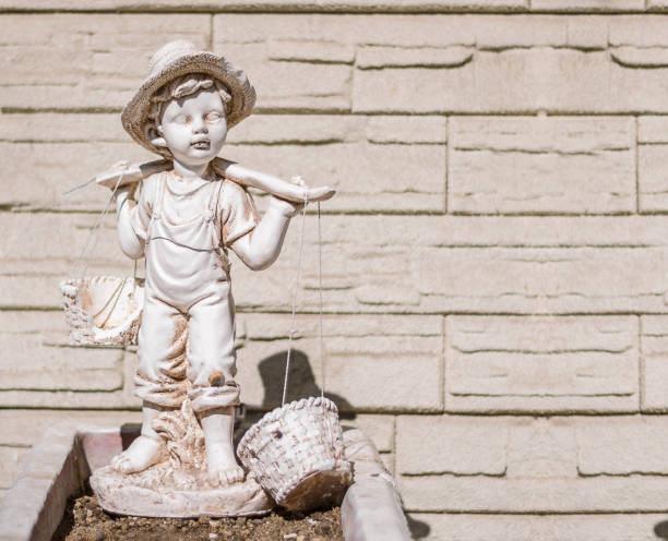 Photo of 3 years old boy in old countryside stone village house. He is wearing a hat and a plaid shirt. Shot under daylight. The house is stone made traditional Turkish style village house and is abandoned.