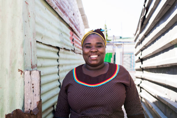madre sorridente in piedi all'aperto - slum living foto e immagini stock