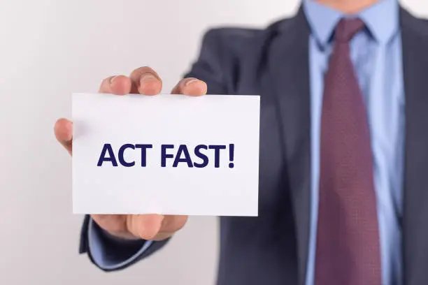Photo of Man showing paper with ACT FAST! text