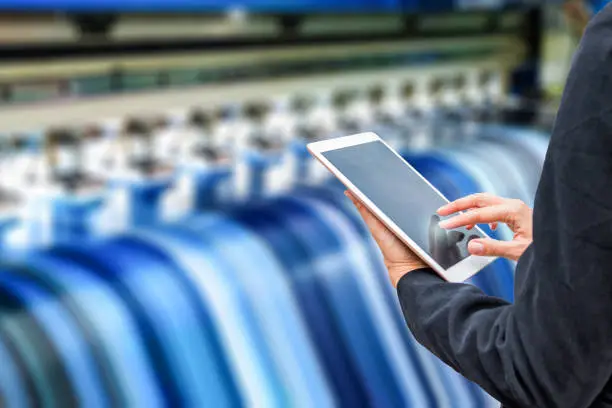 Technician using tablet control with format large inkjet printing blue plate