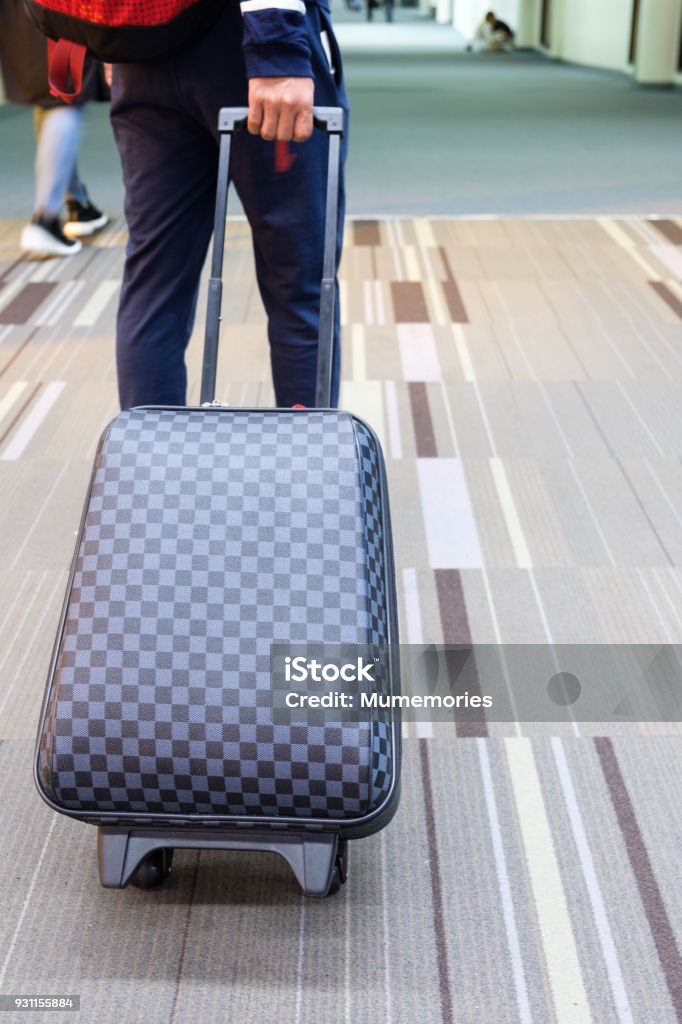Young Traveler Man Dragging Luggage At Airport Stock Photo