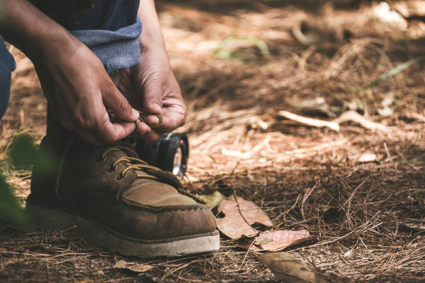 istock Closeup image of a man tying shoelace while trekking in a tropical forest 931159446