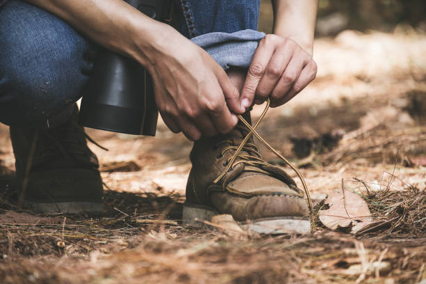 istock Closeup image of a man tying shoelace while trekking in a tropical forest 931159730