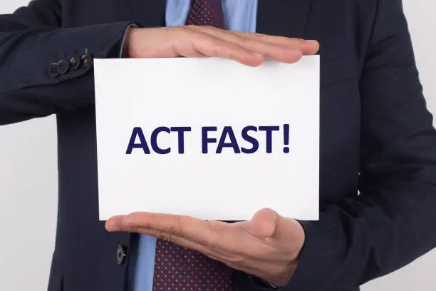 Photo of Man showing paper with ACT FAST! text