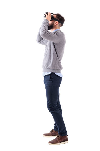 istock Profile view of young man having virtual reality experience holding glasses and looking up 931172336