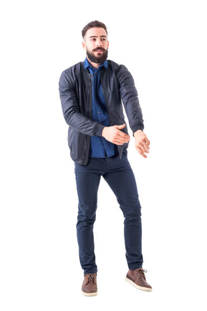 istock Young bearded man getting dressed reaching bomber jacket sleeve looking away. 931173540