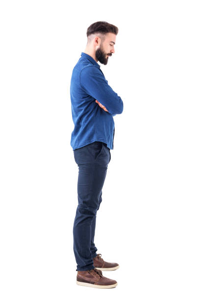 istock Profile view of sad man with bent down head and crossed arms looking down. 931174288