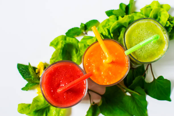 Healthy tomato, avocado and carrot smoothie in a glass isolated on white background