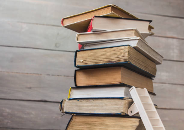 istock ladder on pile of old books on wooden background 931180098