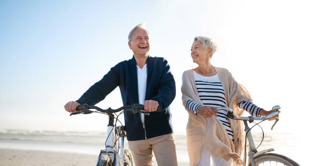 행복 한 해변을 걱정 하지 마세요 - senior couple cycling beach bicycle 뉴스 사진 이미지