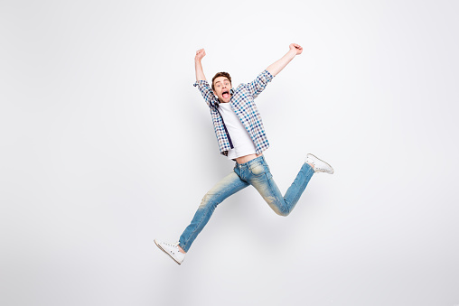 Mid-air shot of mad, crazy, cheerful, successful, lucky guy in casual outfit, jeans, shirt, with bristle, jumping with open mouth, hands up, triumphant, gesturing against white background
