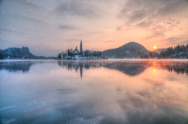 traumhaften sonnenuntergang an der see bled im winter, slowenien - castle slovenia winter snow stock-fotos und bilder