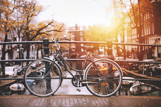 Amsterdam city scene with many bike parkes on typical water canal and bridge in sunny day
