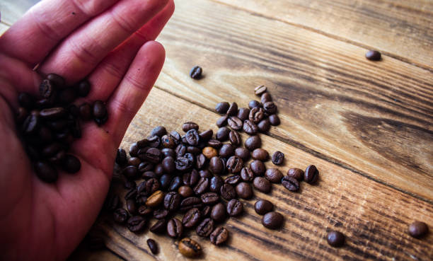 istock coffe beans in men hand on wooden background 931193900