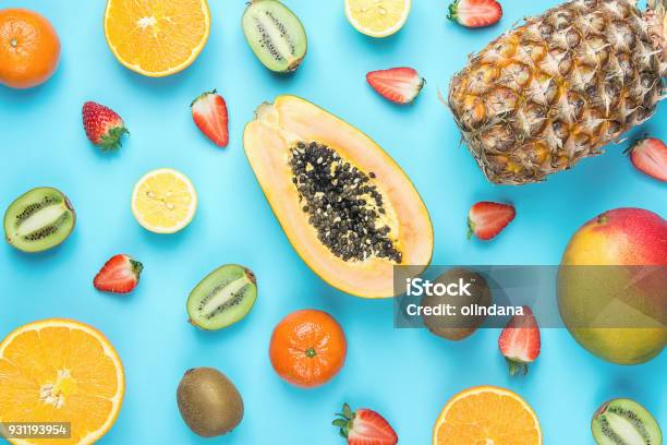 Varietà Di Diversi Frutti Estivi Tropicali Stagionali Papaya Mango Mandarini Citrus Oranges Pineapple Lemons Fragole Kiwi Su Sfondo Blu Vitamine Per La Dieta Sano Lay Piatto - Fotografie stock e altre immagini di Frutta