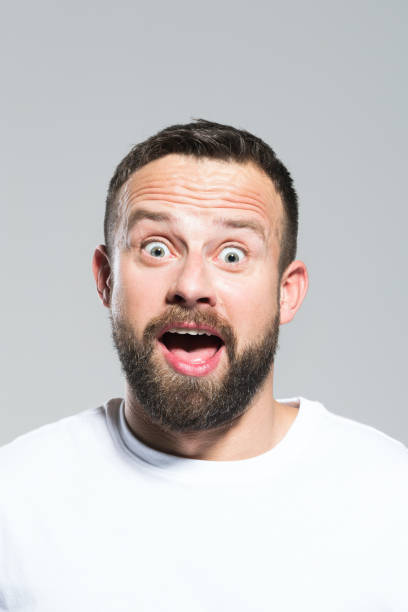 istock Headshot of surprised bearded young man, grey background 931198416