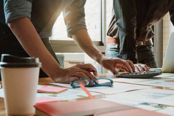 istock Business man analysis on data paper with partner during using calculator for calculating financial at the office - Business team meeting concept 931198548