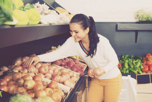 istock Smiling young woman customer examining various onions 931203914