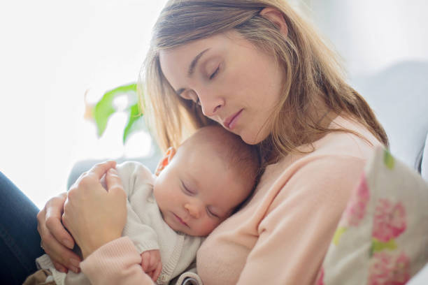 istock Young mother, holding tenderly her newborn baby boy 931205112