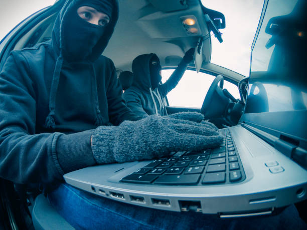 istock Car thief disarming car protections with laptop computer 931207596