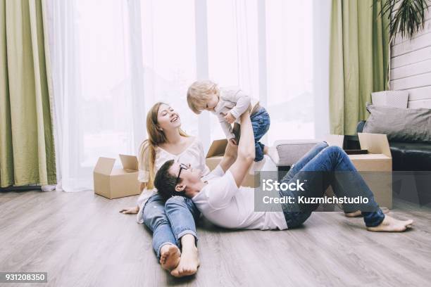 Family Together Happy Young Beautiful With A Little Baby Moves With Boxes To A New Home Stock Photo - Download Image Now