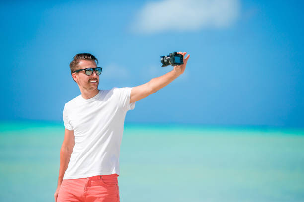 istock Beautiful young man taking a self photo herself on tropical beach 931220644