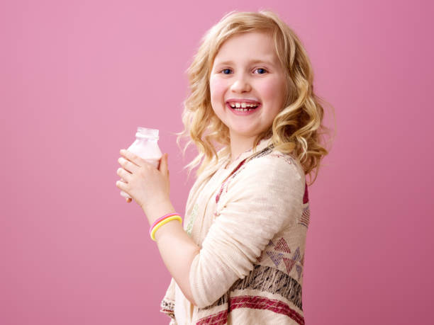 istock smiling child on pink background with farm organic yogurt 931225758