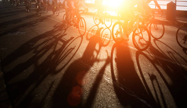 ombre dei ciclisti all'alba - exercising organized group sport outdoors foto e immagini stock