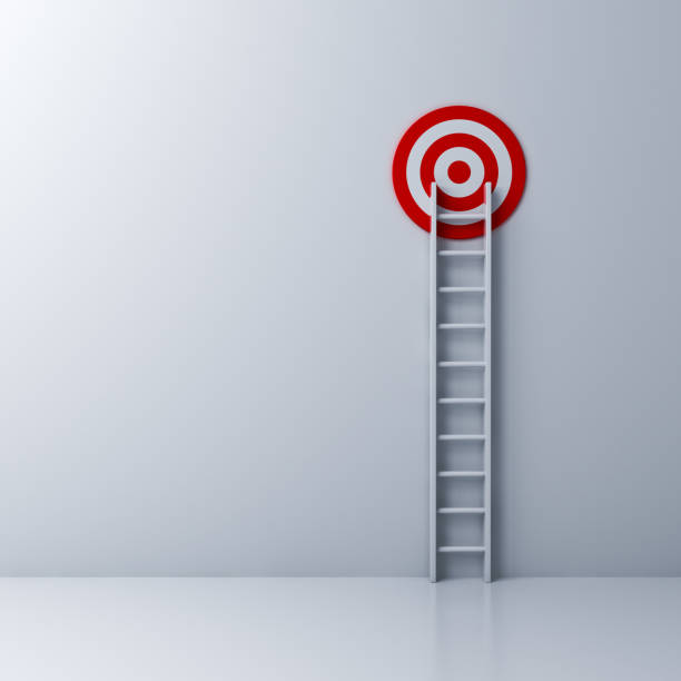 istock Ladder and the red target on white wall background 931227282