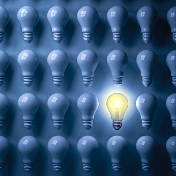 istock One glowing light bulb standing out from the unlit bulbs on dark blue background 931227480
