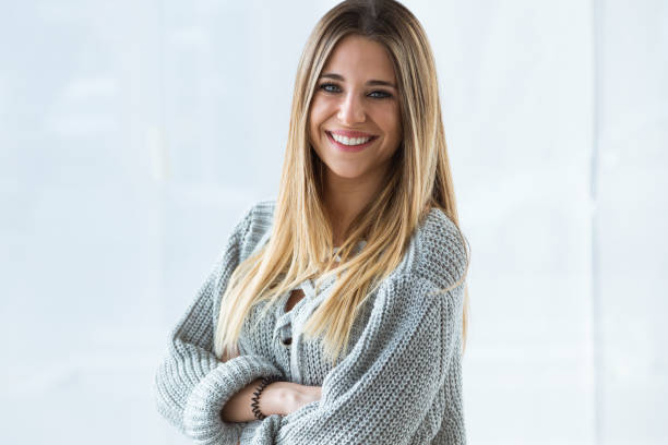 Beautiful young woman looking at camera at home.
