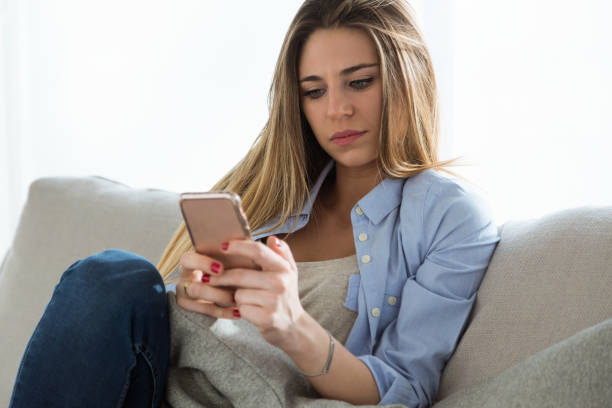 istock Beautiful young woman using her mobile phone at home. 931231622