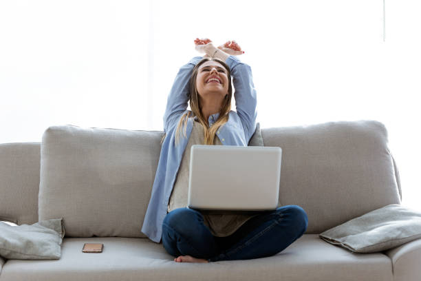 istock Beautiful young woman celebrating a succes while working with laptop at home. 931238020