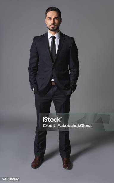 Young Serious Successful Businessman Standing With Hands In Pockets Stock Photo - Download Image Now