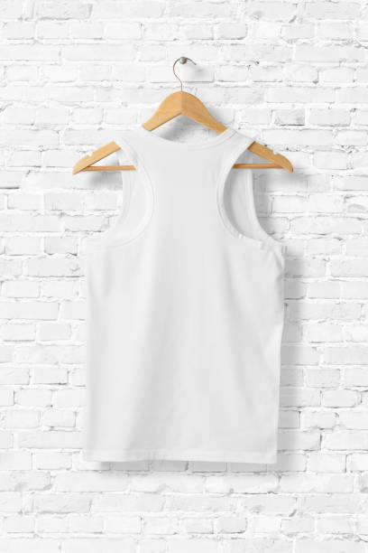 istock White Tank Top Shirt Mock-up hanging on white brick wall, rear view. 931240534